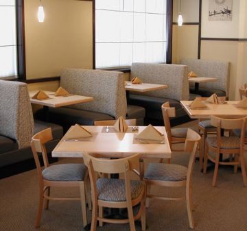 Cozy cafe interior with wooden tables and cushioned booths.
