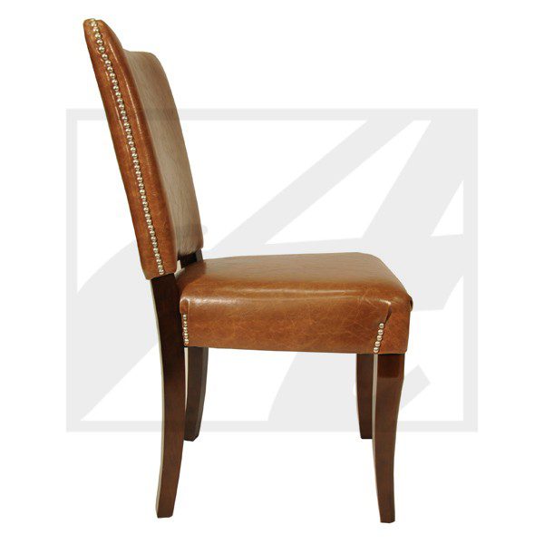 Leather upholstered dining chair with wooden frame and nailhead trim.
