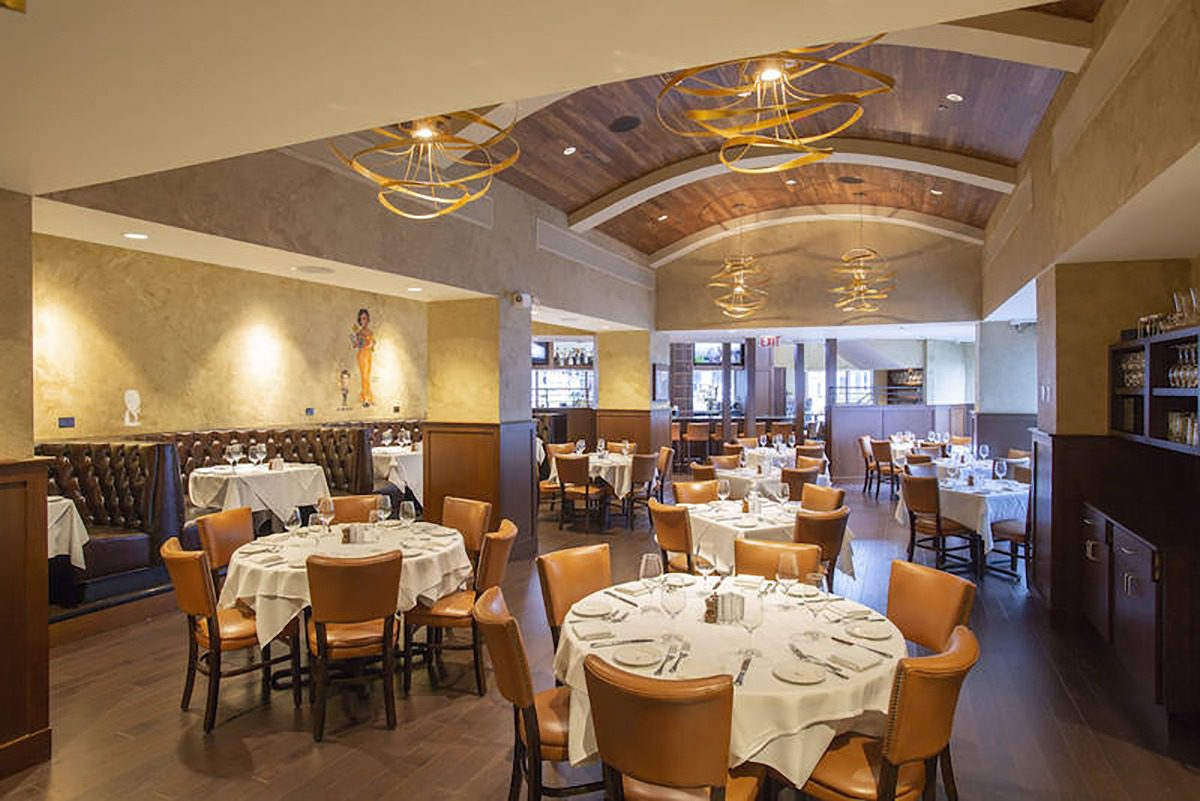 Elegant restaurant dining area with round tables set for guests.