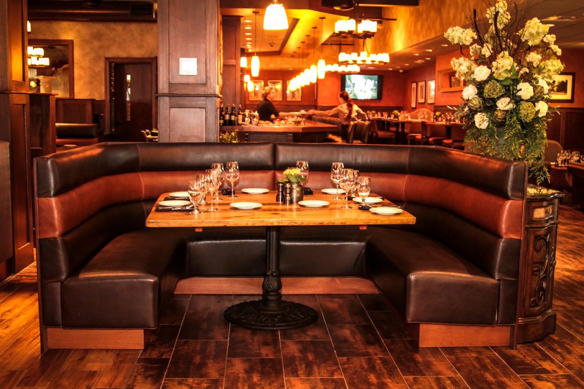 Cozy restaurant booth with warm lighting and elegant table setting.