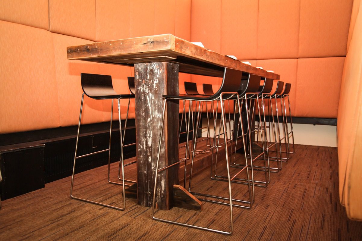 Modern wooden table with high metal stools in a cozy room.