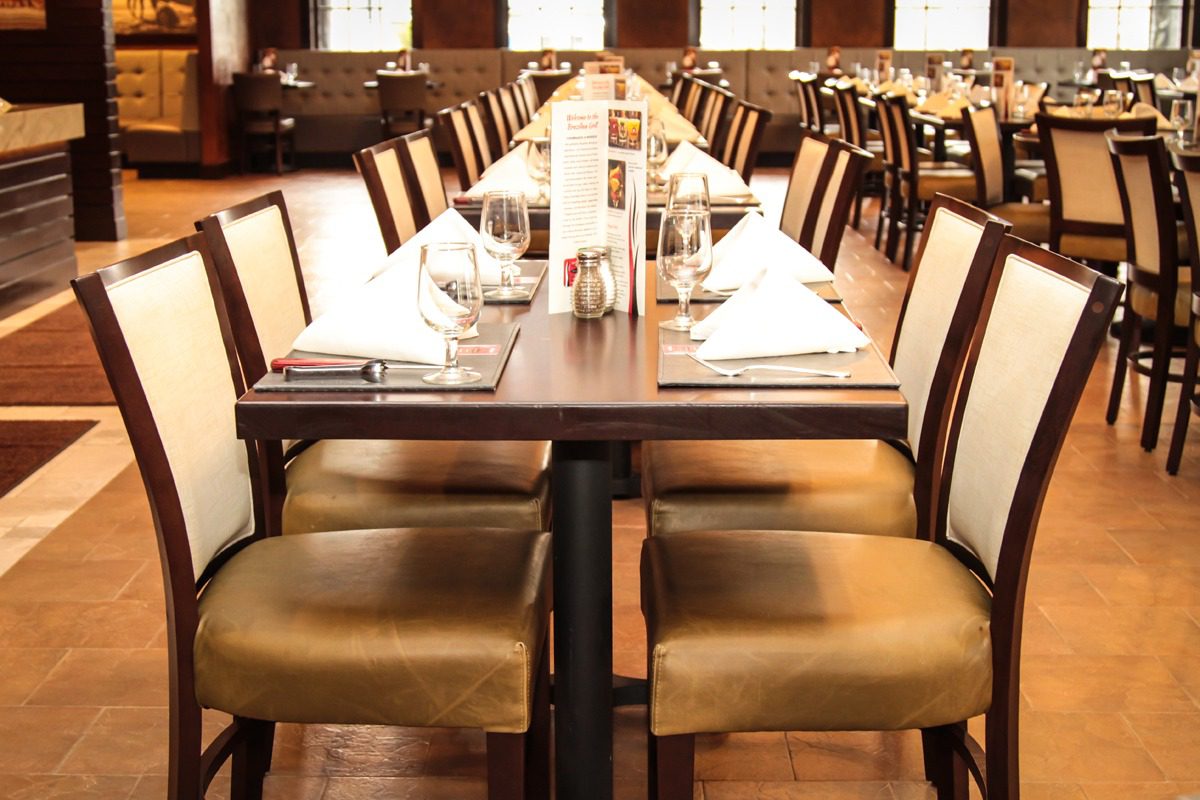 Elegant dining table set with neatly arranged chairs and tableware.