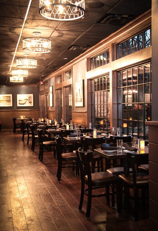 Elegant restaurant interior with wooden decor and neatly arranged tables.