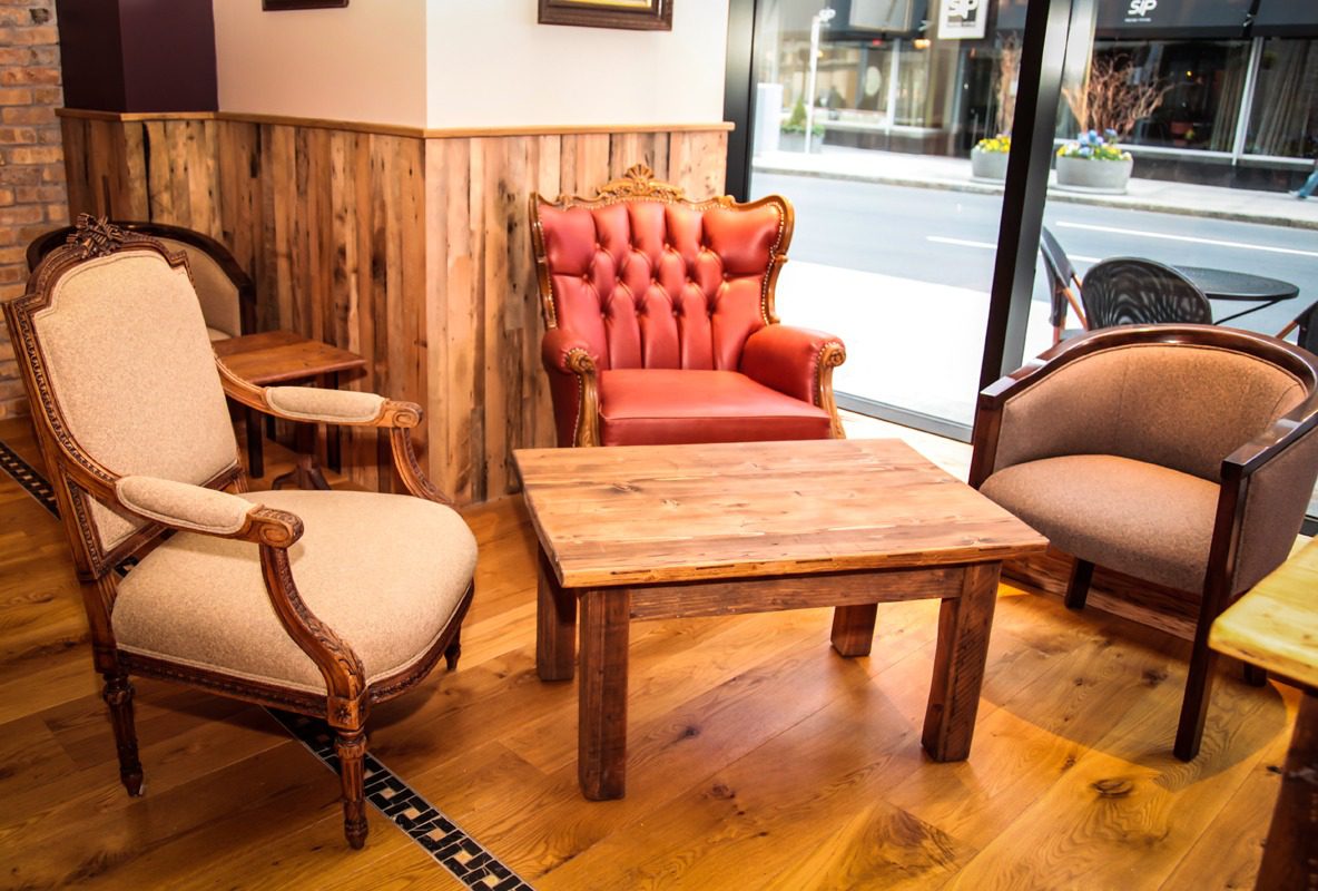 Cozy seating area with wooden furniture and a red armchair by the window.