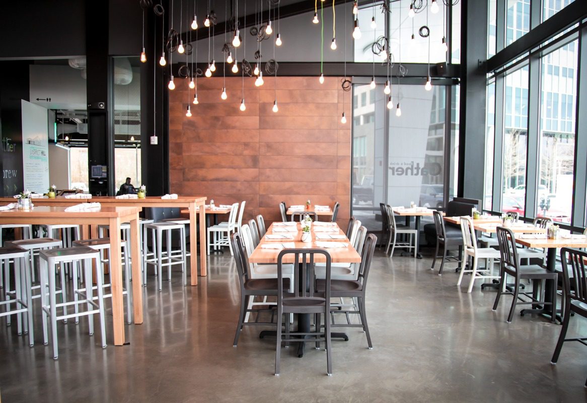 Modern dining area with wooden tables and hanging lights.