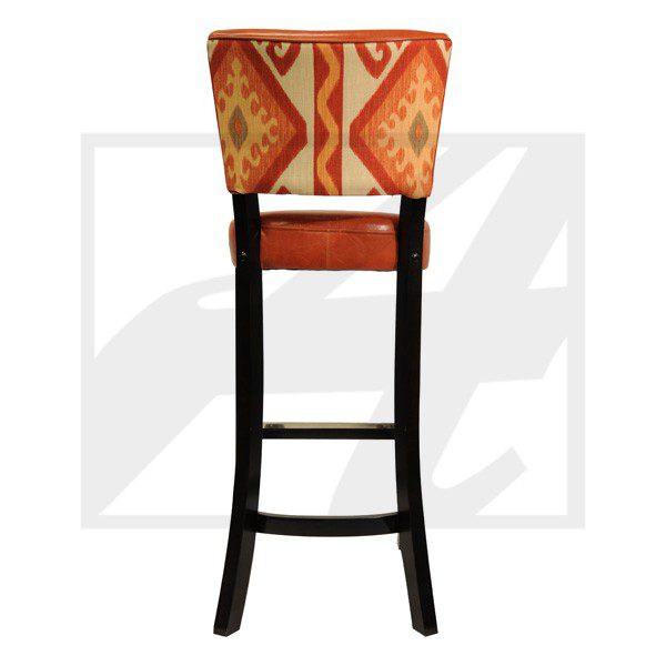 A tall wooden bar stool with a red patterned cushioned seat and backrest.