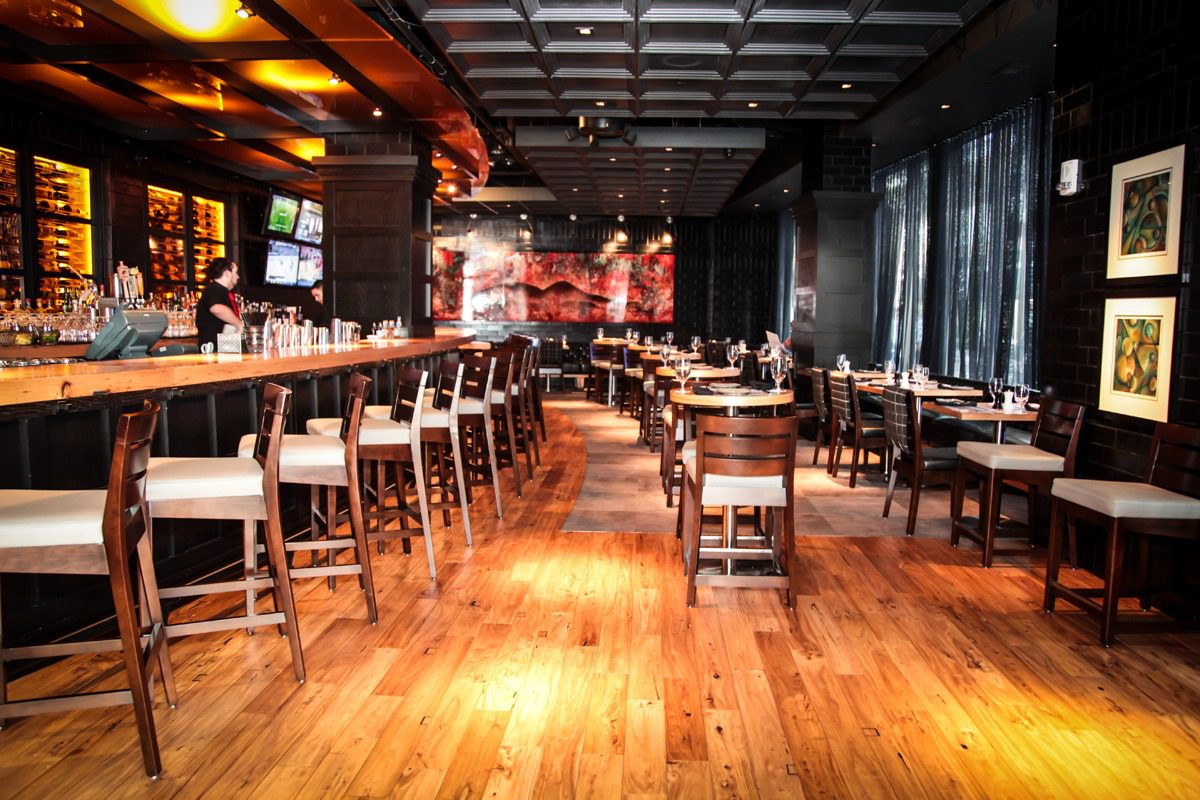 Spacious restaurant interior with wooden floors and modern seating.