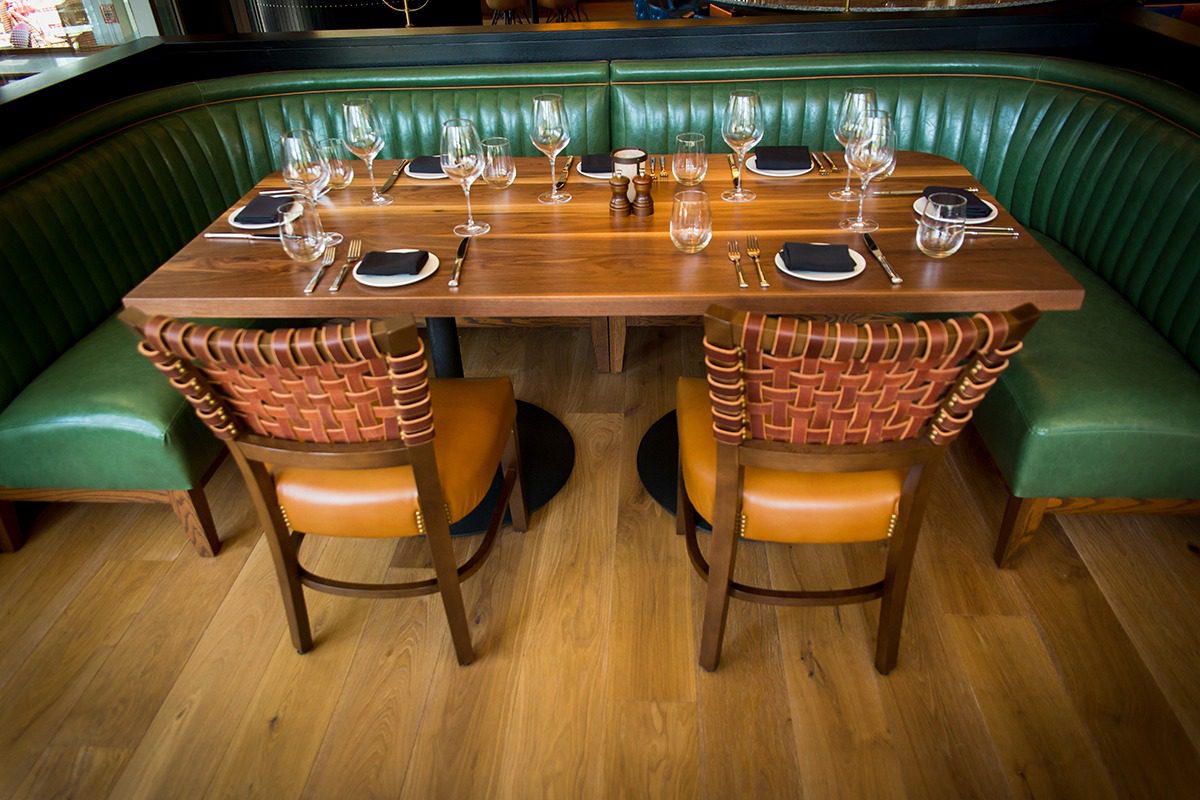 Elegant dining table set with woven chairs in a cozy restaurant.