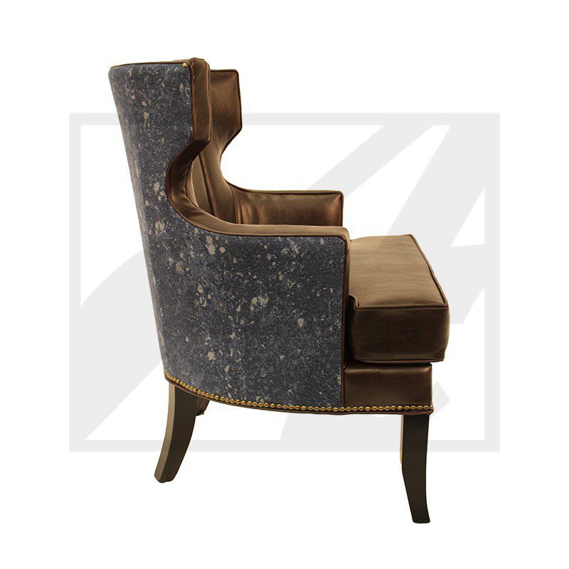 Side view of a vintage upholstered armchair with wooden legs and a velvet cushion.