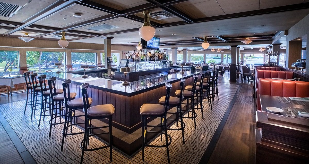 Modern bar interior with stools and panoramic windows.
