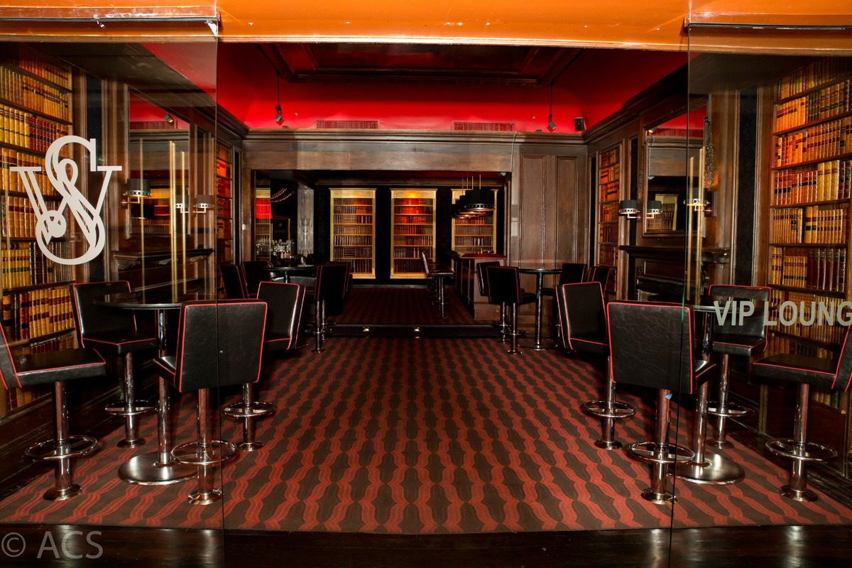 Luxurious restaurant interior with rich red and black tones.