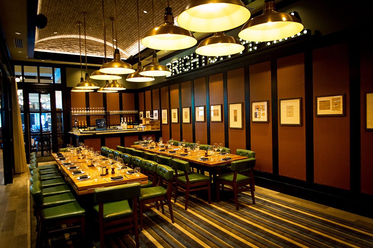 Elegant dining room with long tables and modern pendant lights.