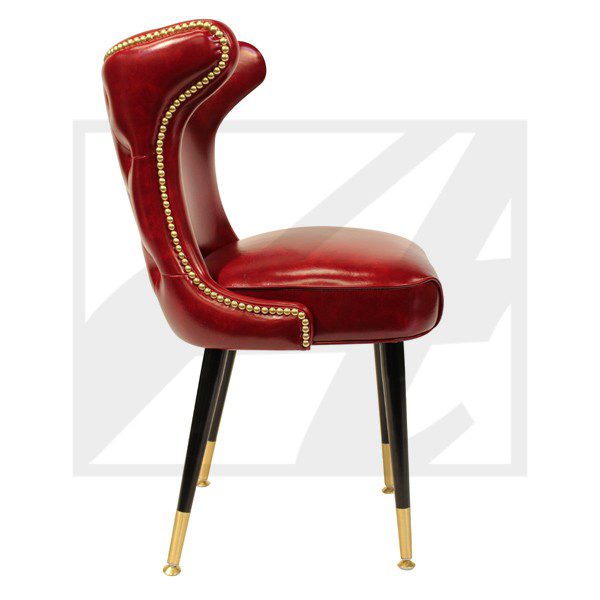 Red leather chair with brass nailhead trim and black legs.