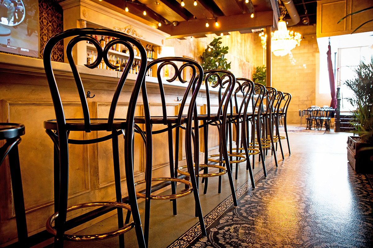 Elegant bar stools lined up in a cozy, warmly lit bar.