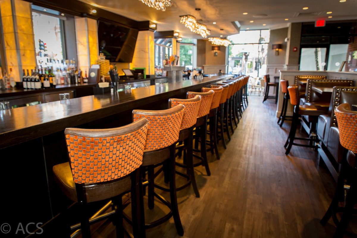 Cozy bar with patterned stools and warm lighting.