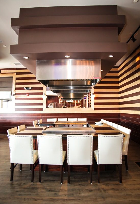 Modern dining area with striped walls and white chairs.
