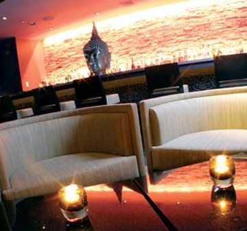 Elegant lounge with cozy seating and candlelit tables.