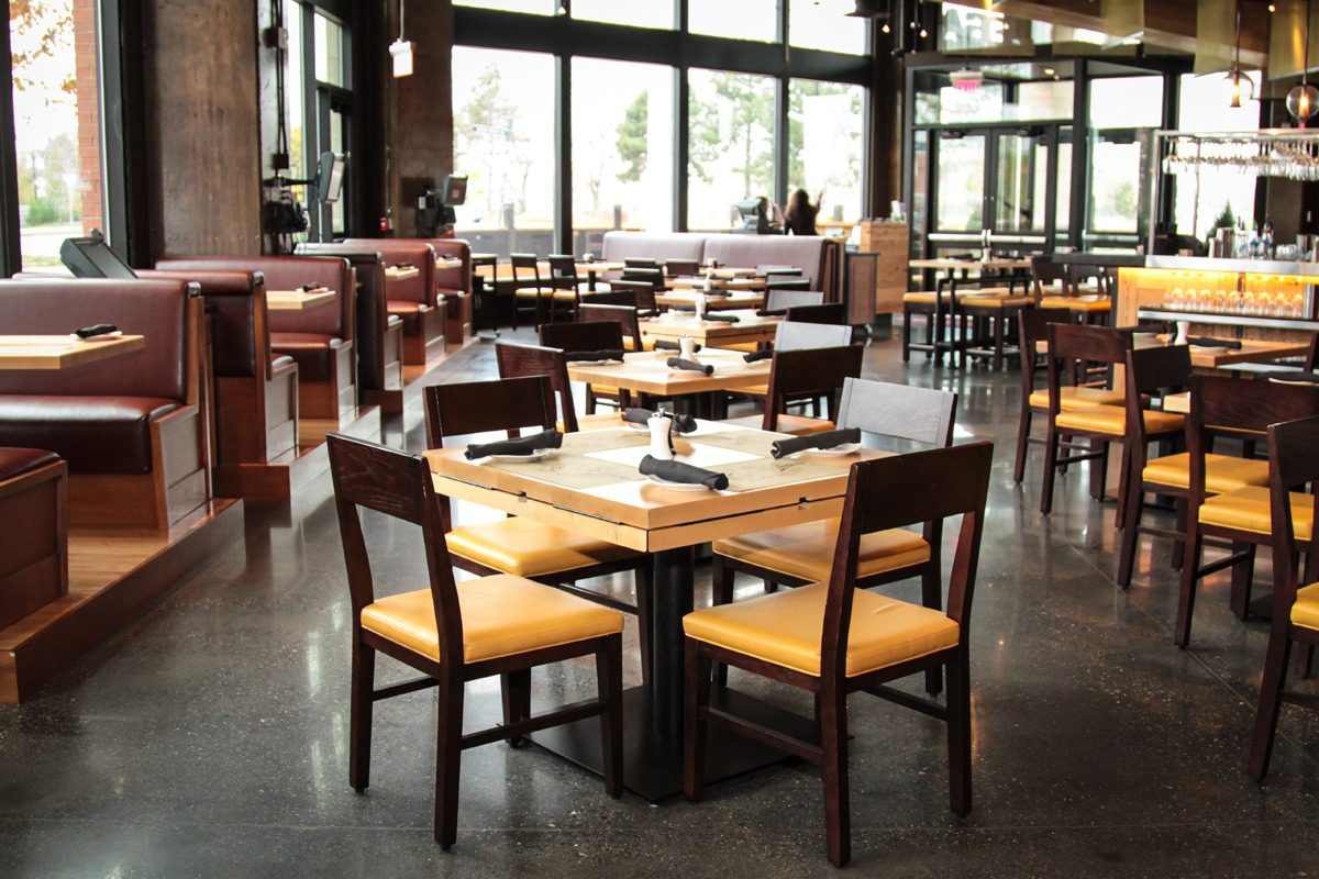 Modern restaurant interior with wooden tables and chairs.