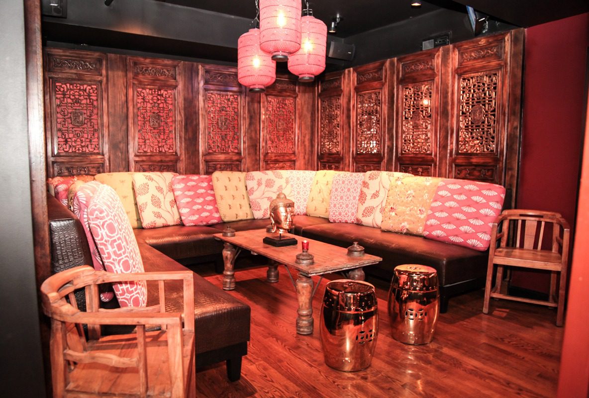 Cozy lounge with wooden decor and red lighting.