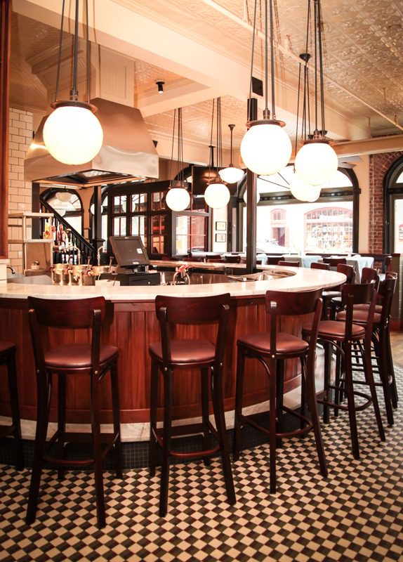 Cozy bar with vintage decor and round hanging lights.