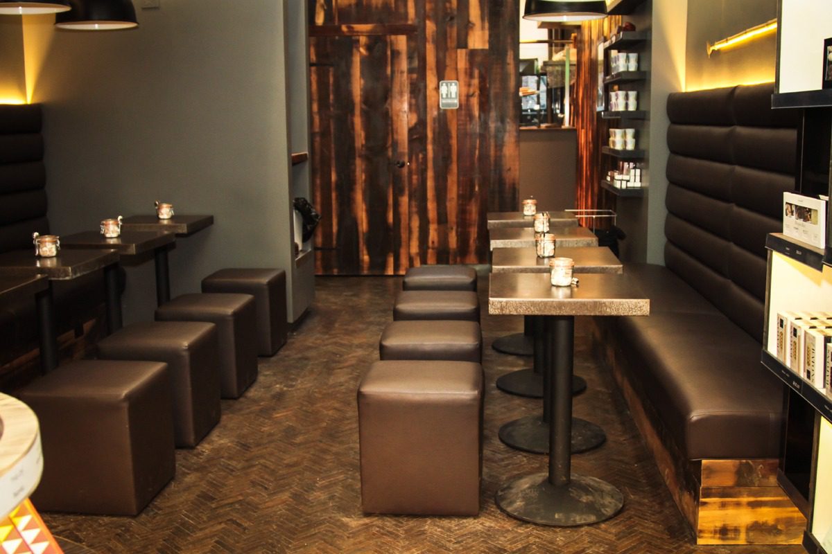 Cozy bar seating with wooden decor and cube stools.