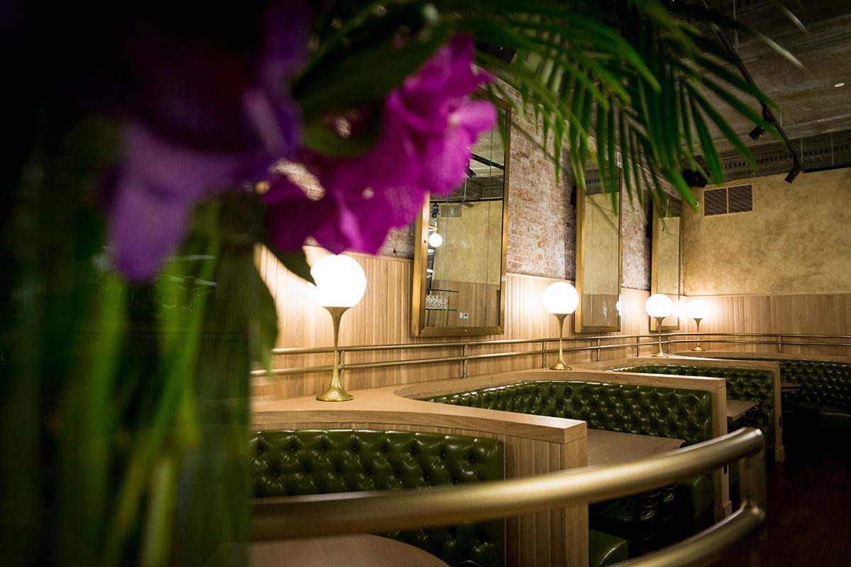 Elegant dining area with green cushioned seating and soft lighting.