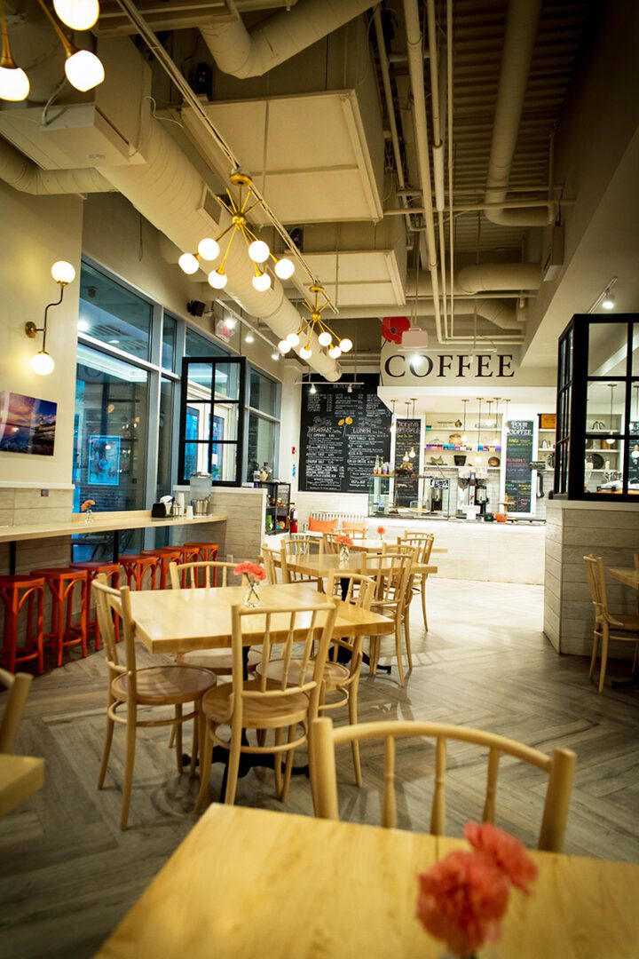 Cozy coffee shop interior with wooden chairs and warm lighting.
