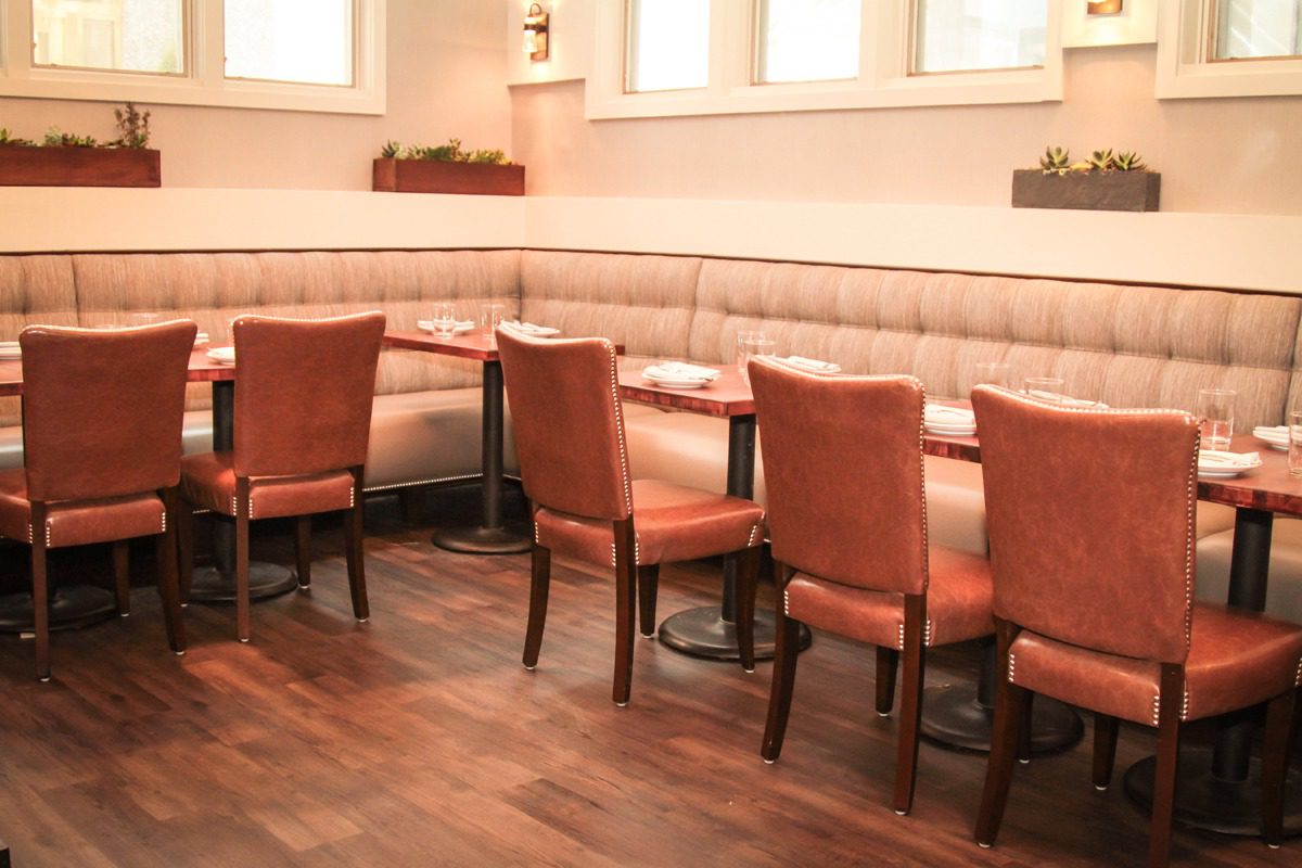 Cozy restaurant corner with leather chairs and cushioned bench seating.