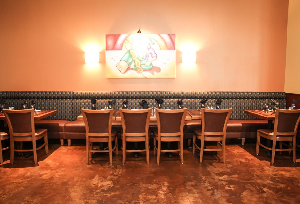 A cozy dining area with a long wooden table and cushioned bench seating.