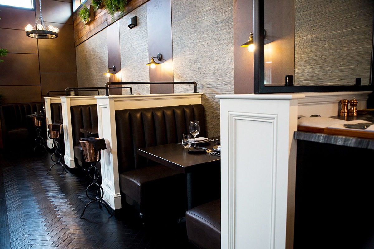 Cozy diner booths with vintage-style lighting and dark leather seats.
