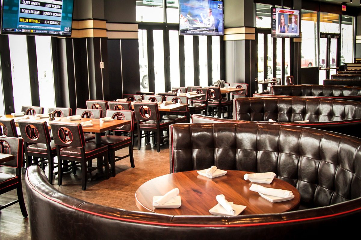 Cozy restaurant dining area with leather booths and wooden tables.
