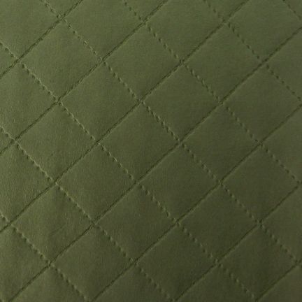 Close-up of quilted green fabric with diamond stitching.