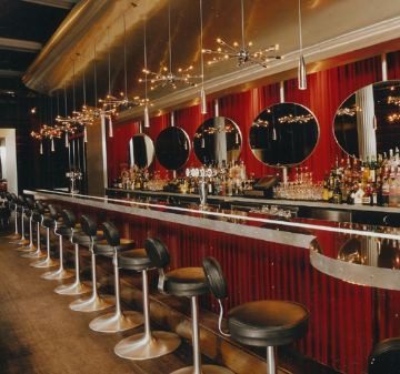 Elegant bar with modern stools and warm lighting.