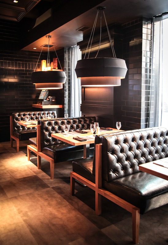 Elegant restaurant seating with brown leather booths and pendant lights.