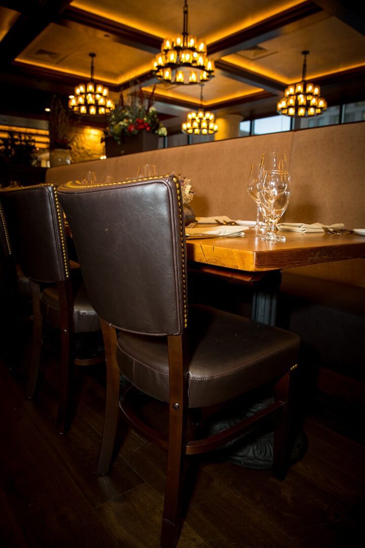 Cozy restaurant booth with wooden table and leather chairs.
