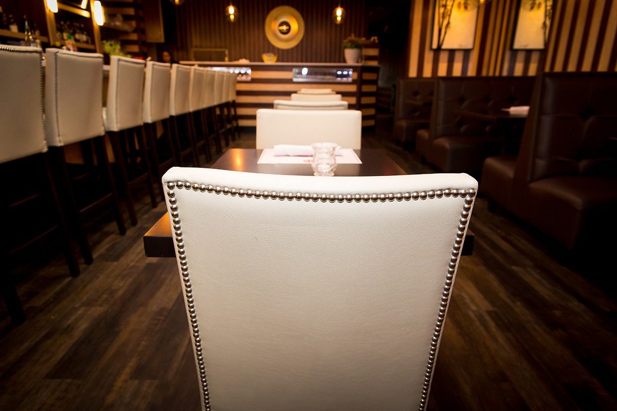 Elegant white leather chair in a stylish restaurant setting.