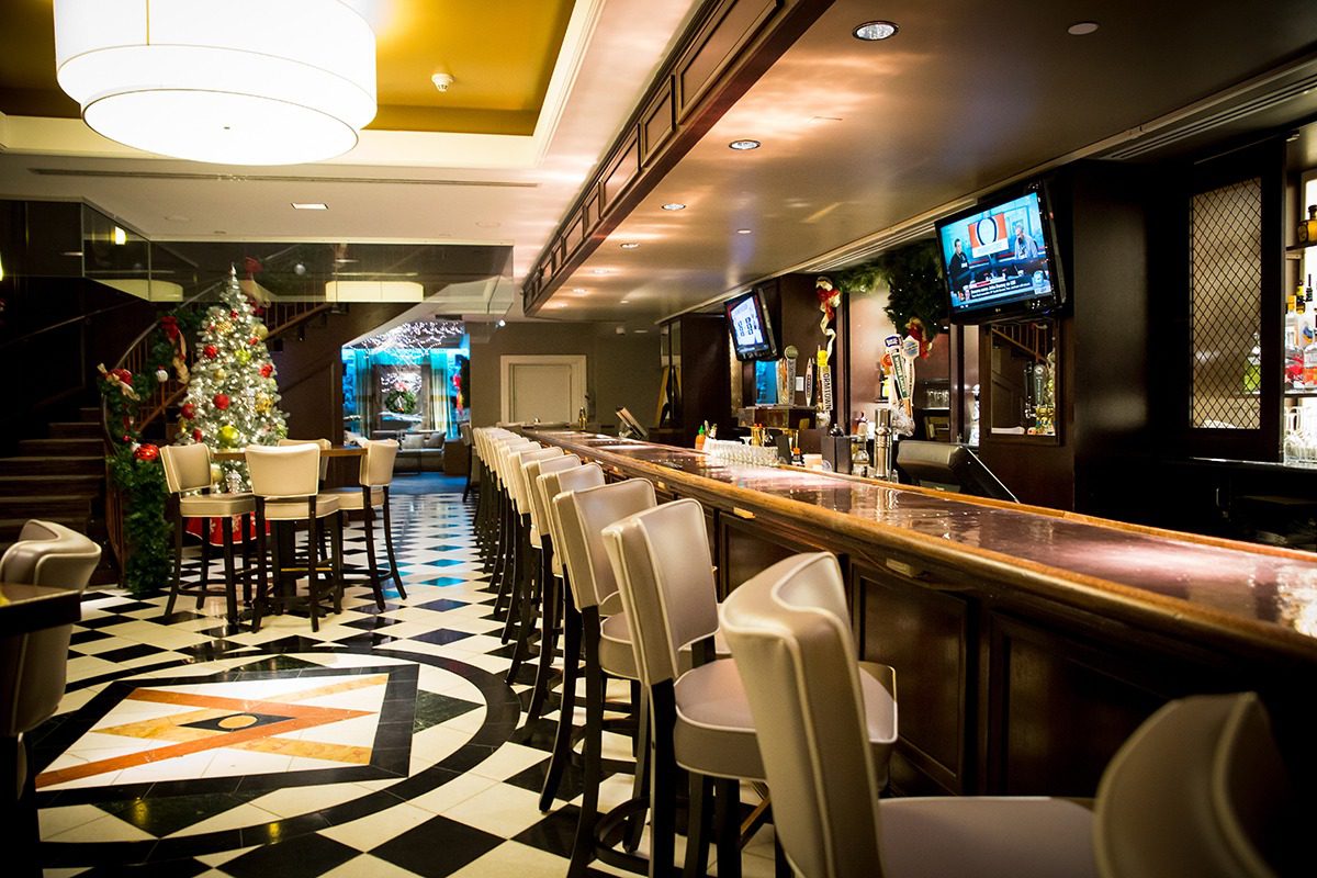 Elegant bar interior with checkered floor and cozy seating.