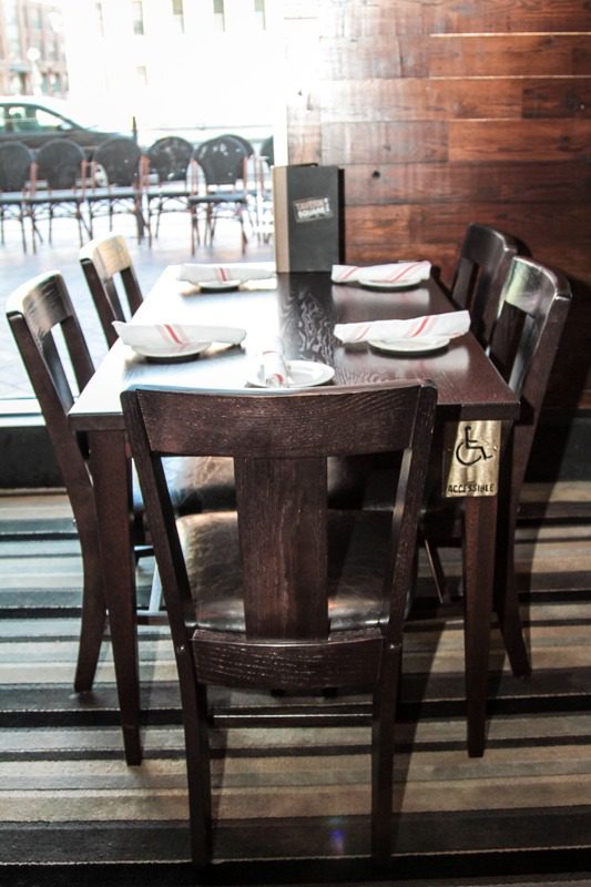 Rustic wooden dining table set with neatly arranged plates and glasses.
