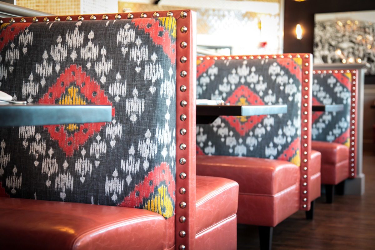 Cozy restaurant booths with patterned fabric and leather seats.
