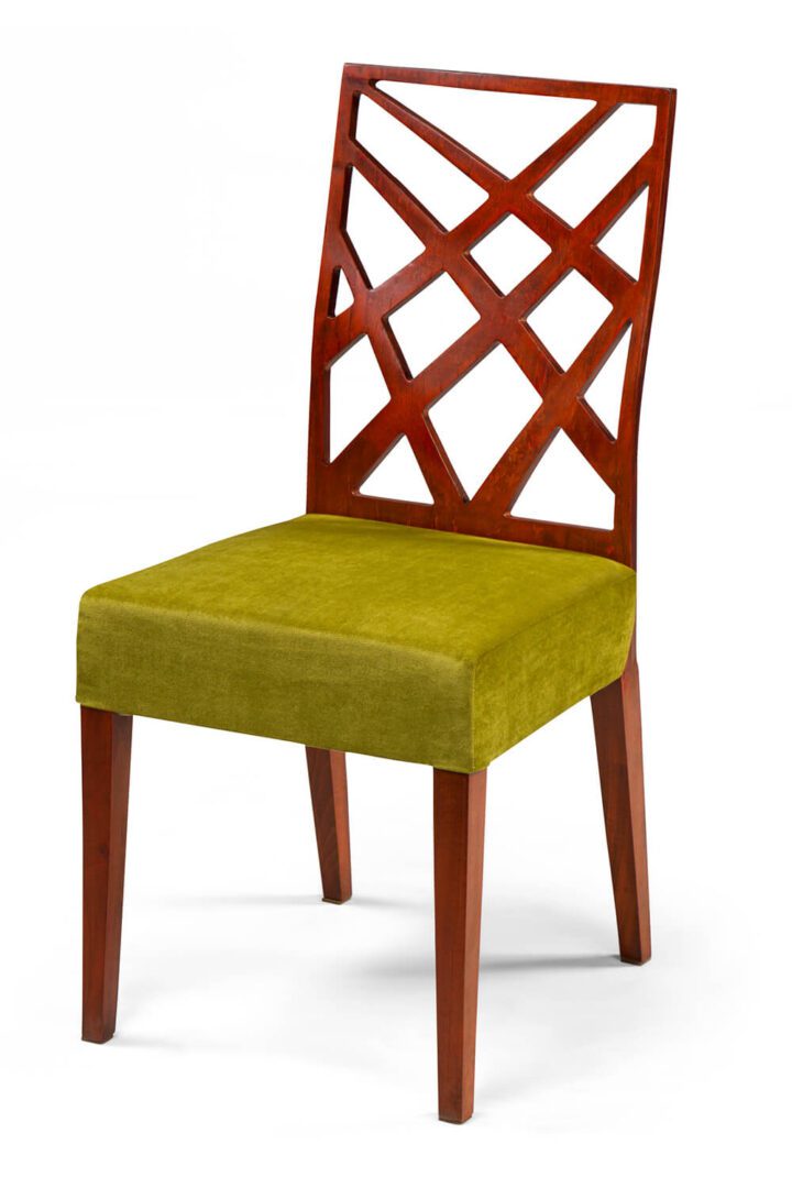 Wooden chair with green cushioned seat and lattice backrest.
