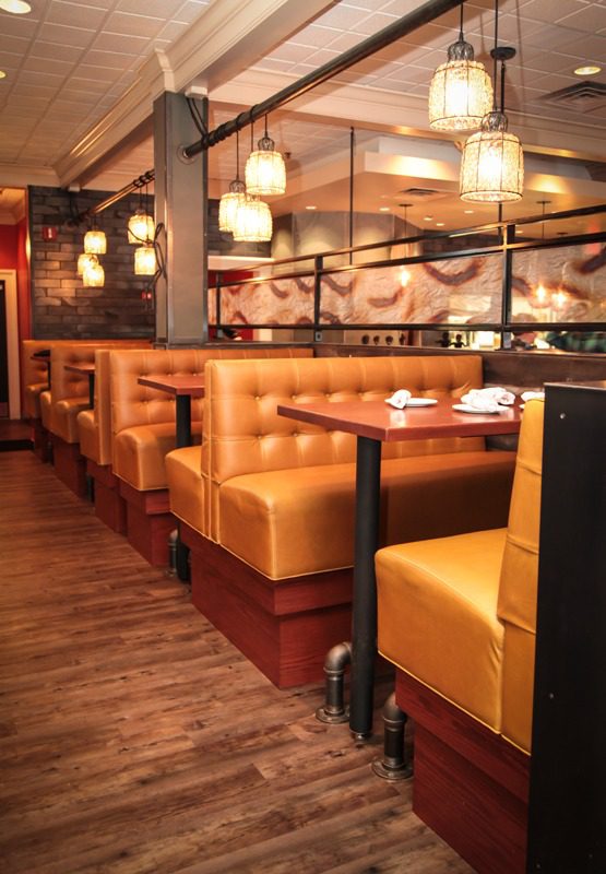 Cozy restaurant booths with warm lighting and wooden floors.