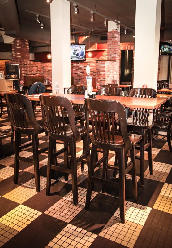 Empty restaurant dining area with wooden chairs and tables.