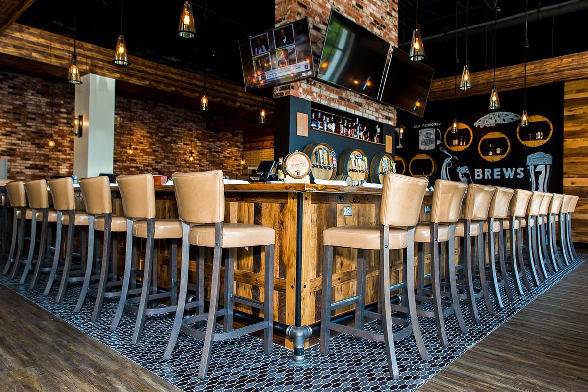 Cozy bar with high chairs and warm lighting.