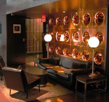 Chic lounge with copper wall decor and modern lighting.
