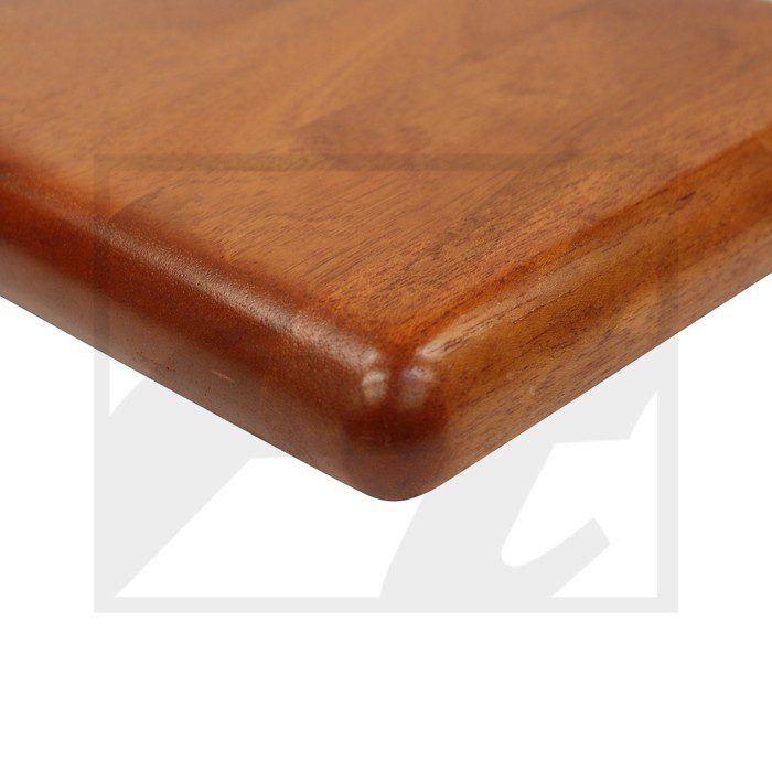 Close-up of a polished wooden table corner with rounded edges.