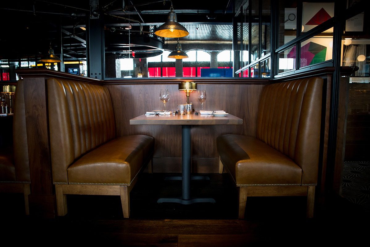 Cozy leather booth seating with a neatly set table in a modern restaurant.