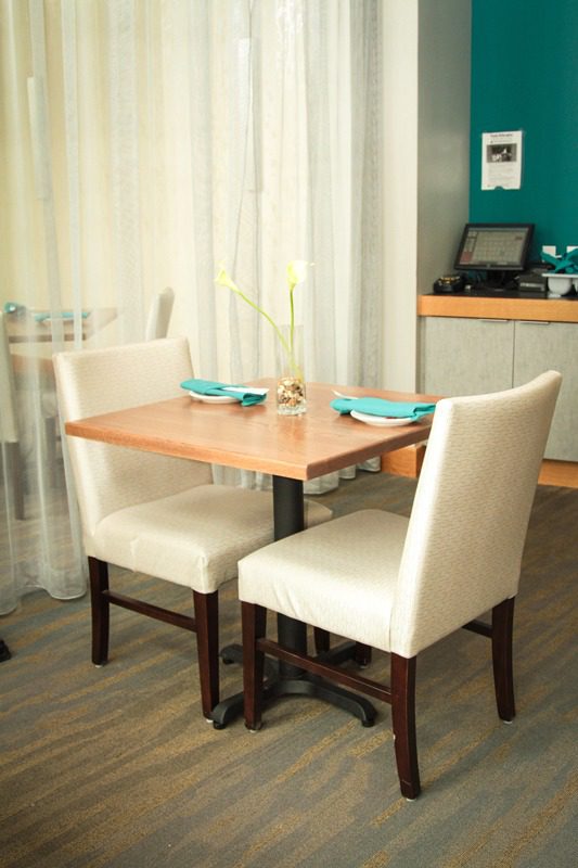 Cozy dining nook with a wooden table and cream-colored chairs.