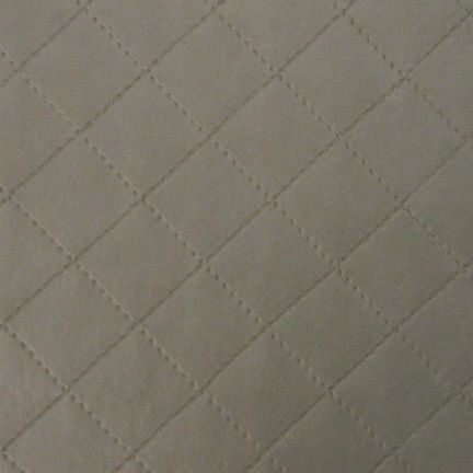 Close-up of a textured quilted fabric with diamond patterns.