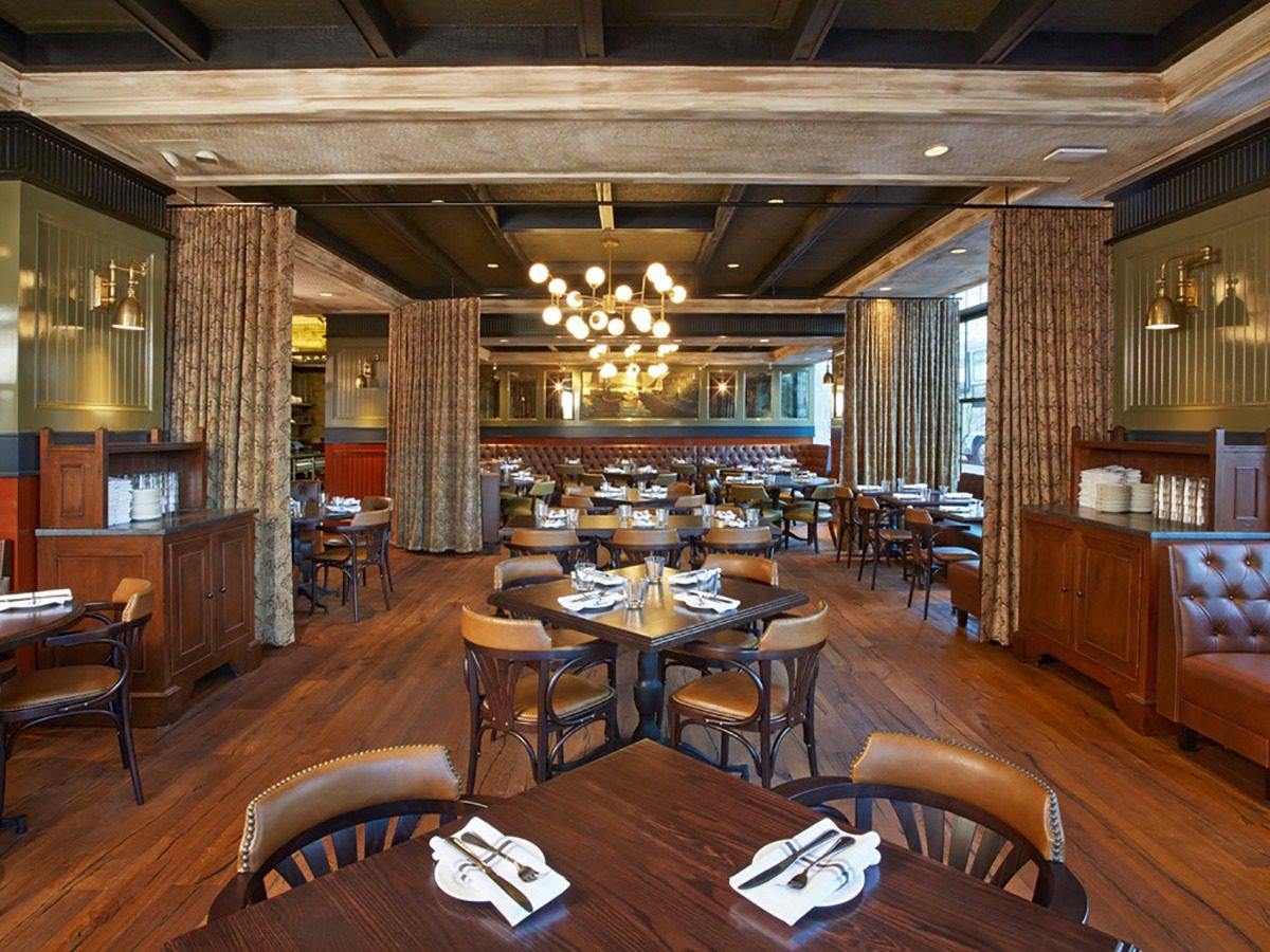 Cozy rustic restaurant interior with wooden beams and elegant lighting.