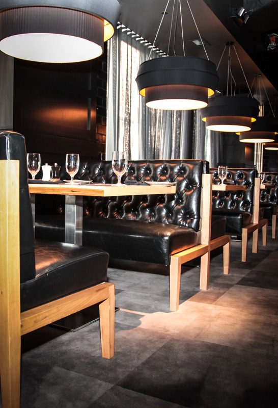 Elegant restaurant seating with tufted leather banquettes and modern lighting.